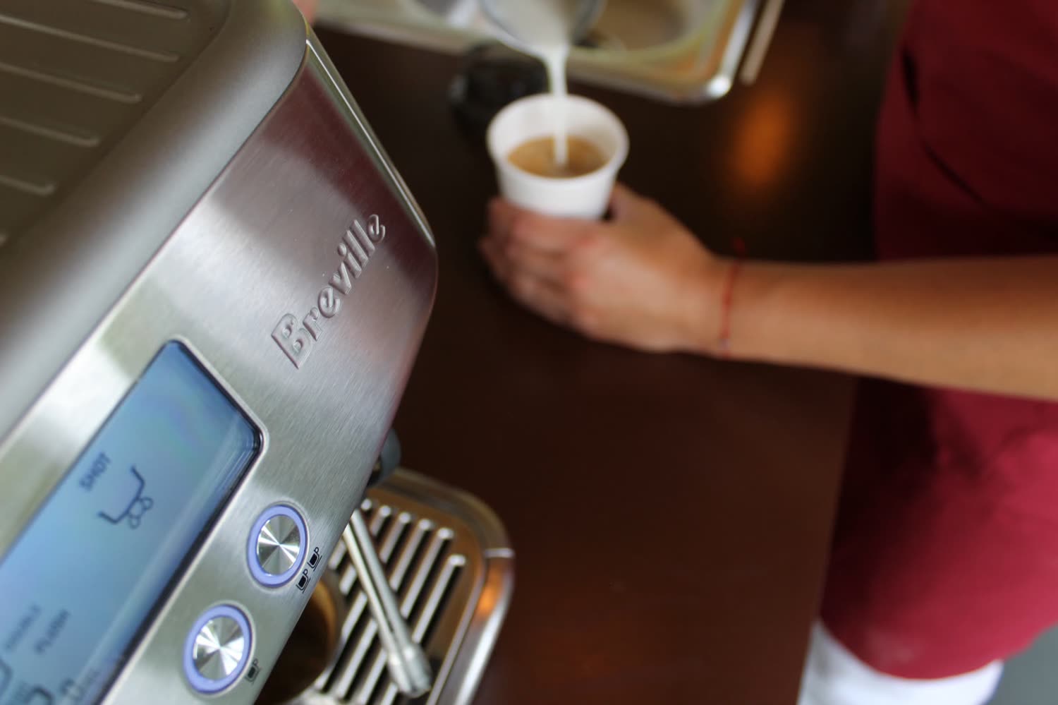 Barista sirviendo una bebida recién preparada en el carrito